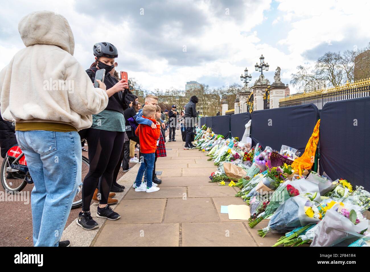 11 aprile 2021, Londra, Regno Unito - le persone che guardano i fiori sono state tribute al principe Filippo, duca di Edimburgo fuori da Buckingham Palace dopo la sua morte il 9 aprile Foto Stock