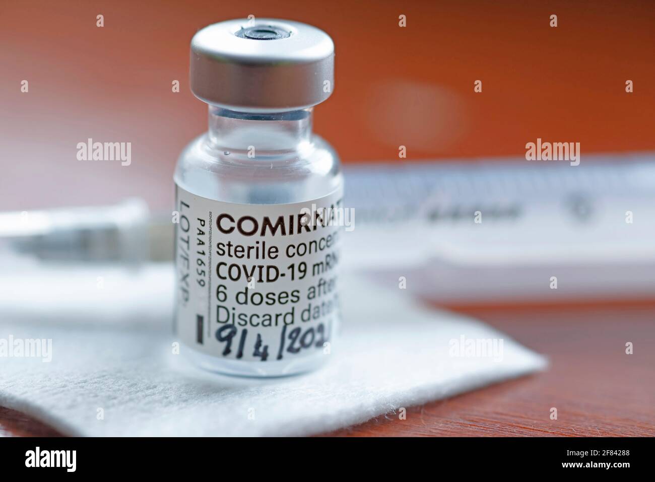 Genova - Aprile 2021, Comirnaty, vaccino RNA contro covid-19, sviluppato da Pfizer BioNTech su sfondo rosso Foto Stock