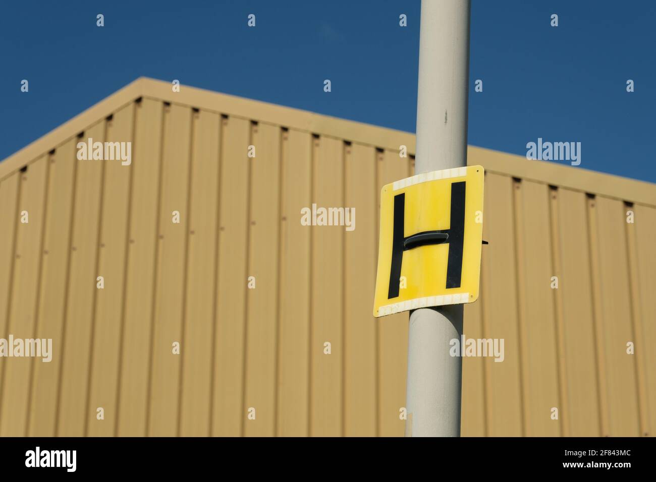 La lettera H su un cartello giallo apponibile ad un lampione che indica un punto Hydrant su una strada a Preston, Regno Unito. Foto Stock