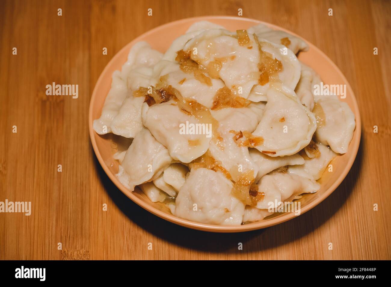 Gnocchi in ciotola con cipolle fritte. Gnocchi, ripieni di purè di patate serviti con cipolla fritta Foto Stock