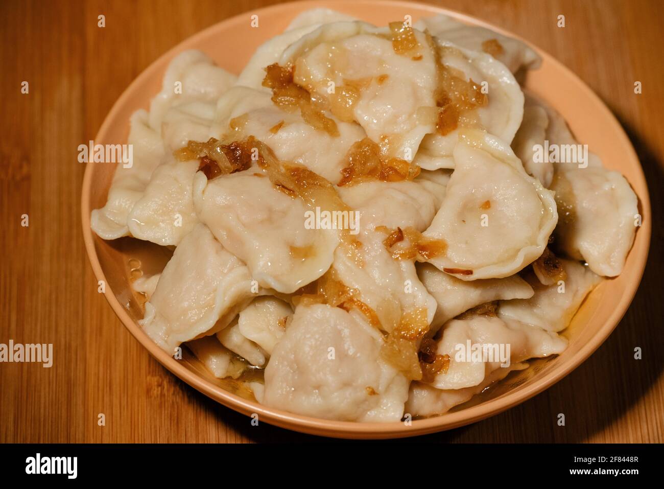 Gnocchi in ciotola con cipolle fritte. Gnocchi, ripieni di purè di patate serviti con cipolla fritta Foto Stock