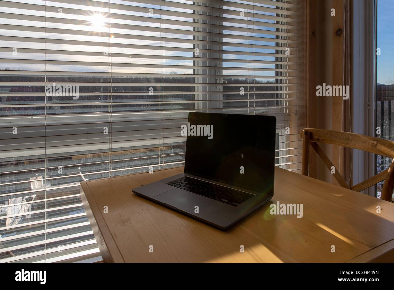 vista di un computer portatile aperto su un tavolo con un finestra dietro Foto Stock