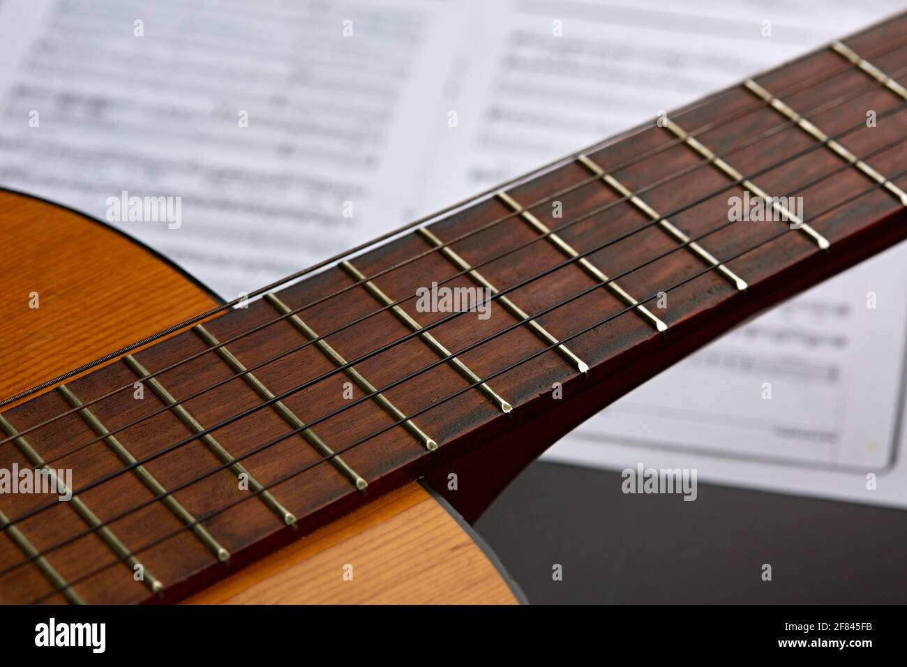 Chitarra acustica, libro di musica sullo sfondo, nessuno Foto Stock