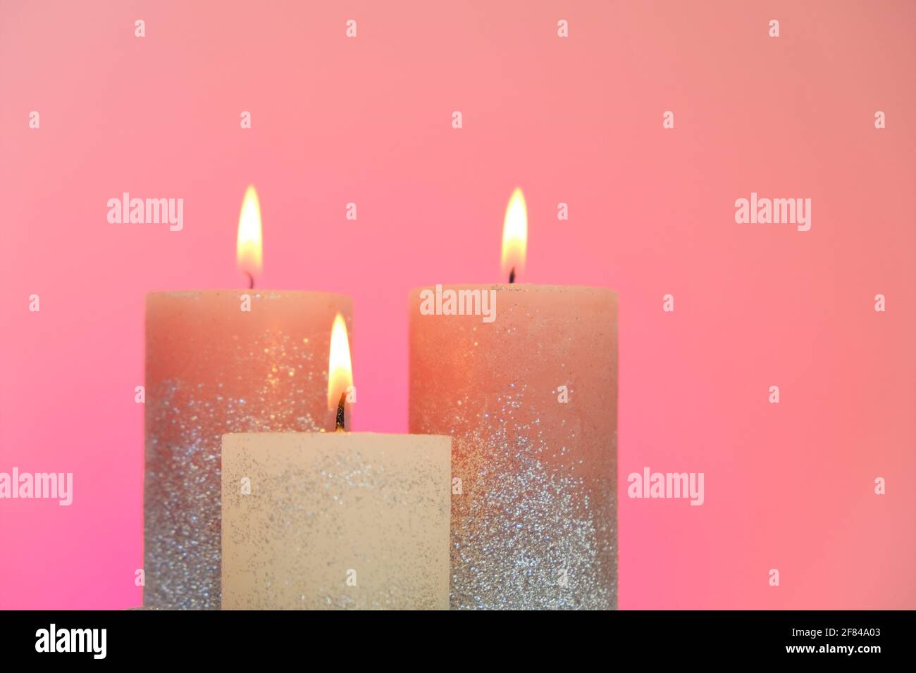 Set candele. Candele festive con glitter su sfondo rosa. Candela fiamma. Foto Stock