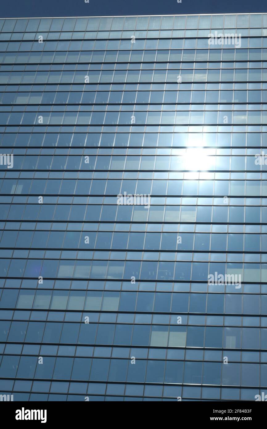 Glas facciata di un edificio aziendale con riflettendo sun nel quartiere di Ginza, Tokyo, Giappone Foto Stock