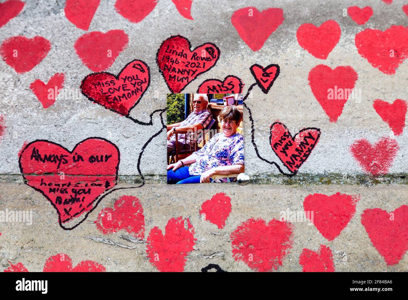 11 aprile 2021, Londra, Regno Unito - Foto e cuori disegnati sul National COVID Memorial Wall lungo la South Bank come tributo a coloro che sono morti durante la pandemia del coronavirus Foto Stock