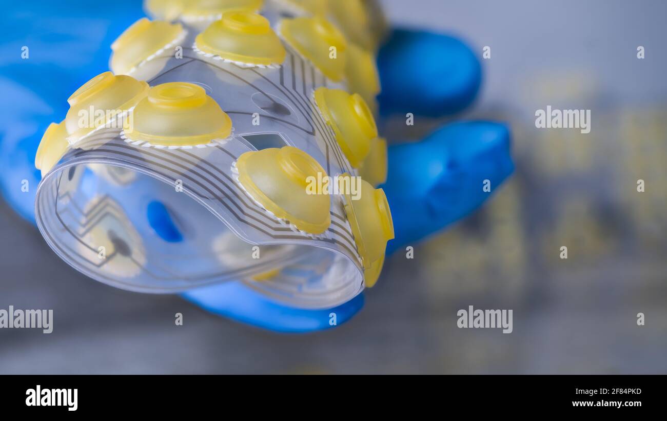 Circuito stampato flessibile elettronico arrotolato su mano umana in dettaglio artistico. Tecnico specializzato nella tenuta di FPC con pulsanti di commutazione in silicone. Foto Stock