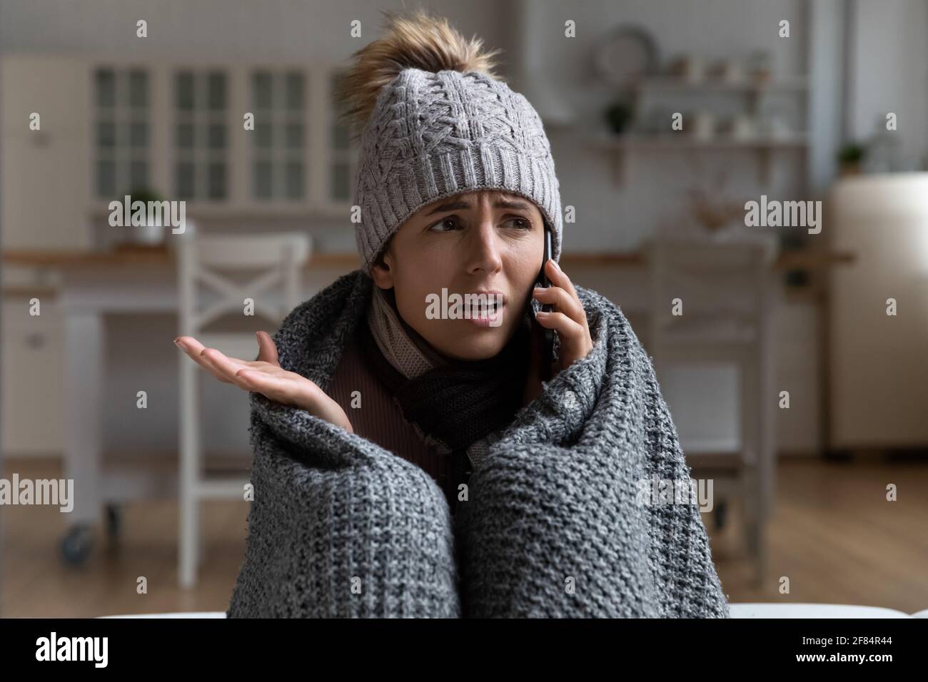 Giovane donna inquilino chiamata casa di gestione si lamentano per freddo Foto Stock