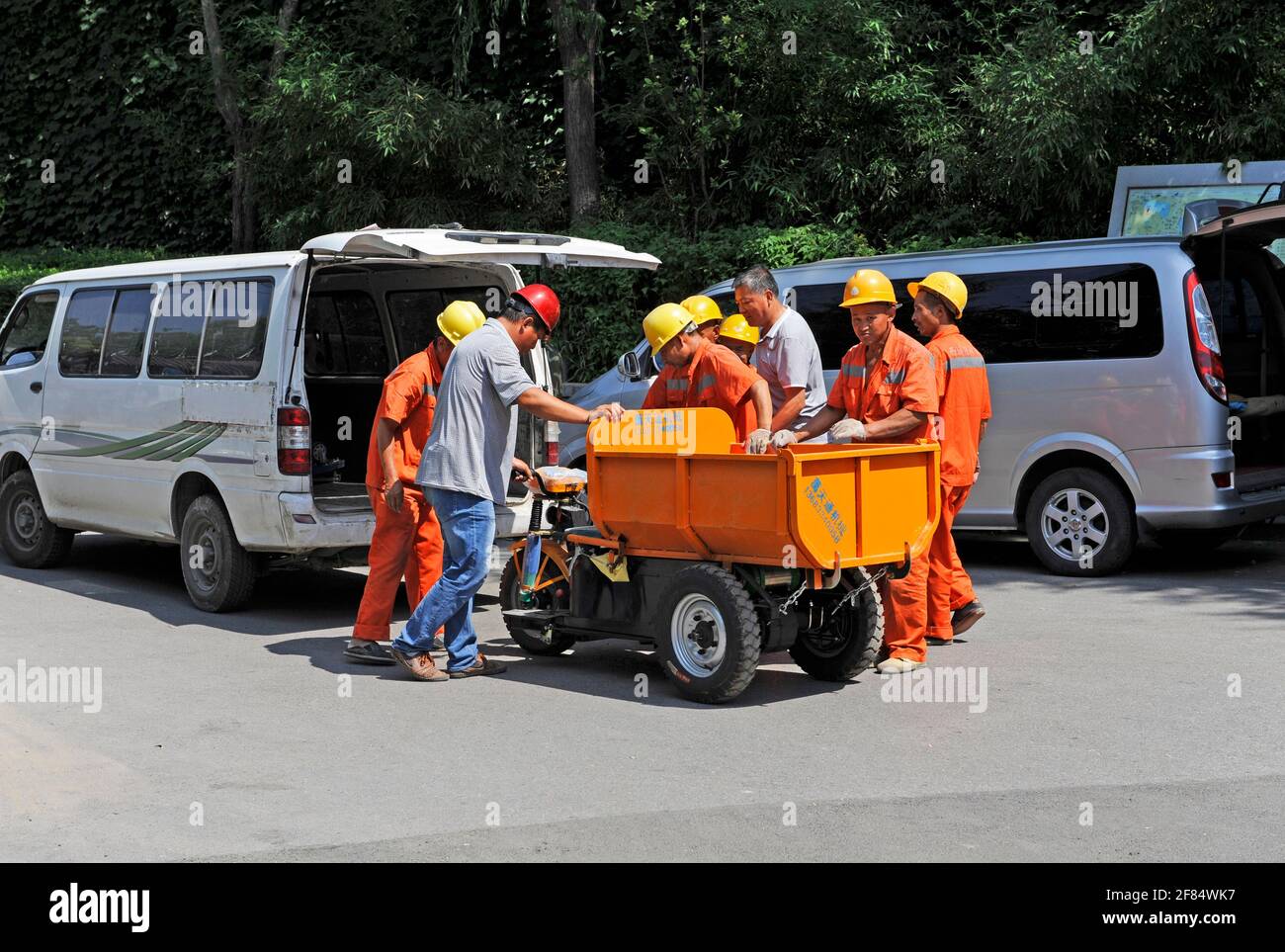 I lavoratori municipali si trovano a Pechino, in Cina, nella zona di Houhai, in un nuovo mini camion a tre ruote Foto Stock