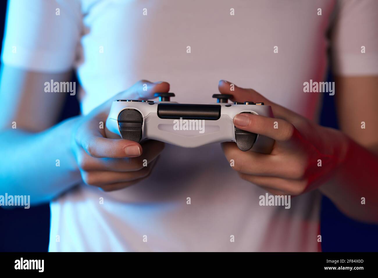 mani femminili che giocano a videogiochi sulla console Foto Stock