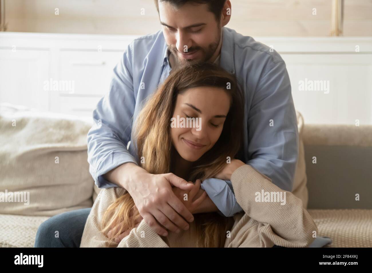 Giovane coppia caucasica che si accoccolava a casa Foto Stock