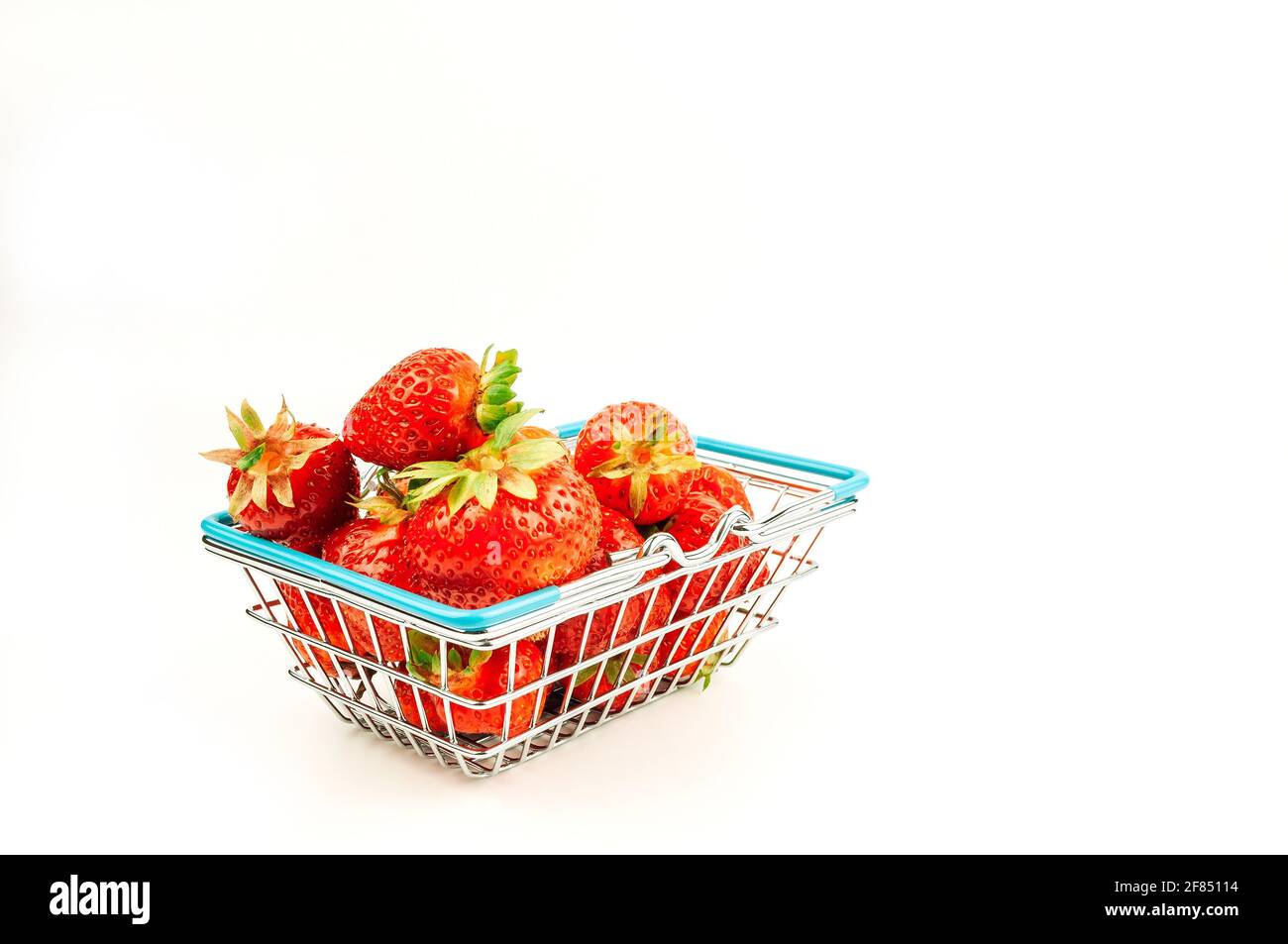 Cestino di alimentari con fragole su uno sfondo bianco isolato. Il concetto di shopping online su internet frutta fresca e frutti di bosco. Foto Stock