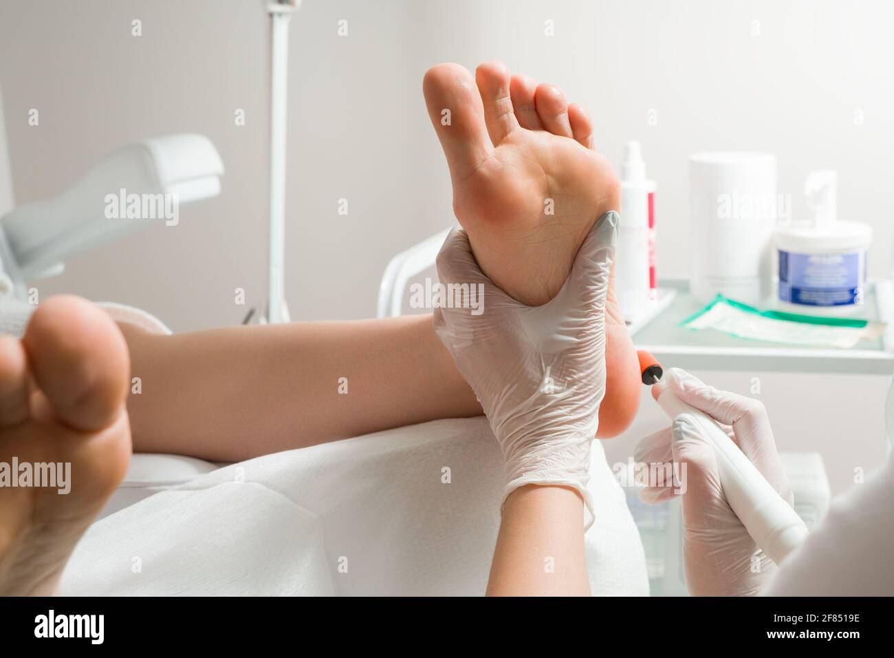 Medico di Podiatrist, esegue la procedura di trattamento delle gambe di una donna. Procedure cosmetiche dei piedi Foto Stock