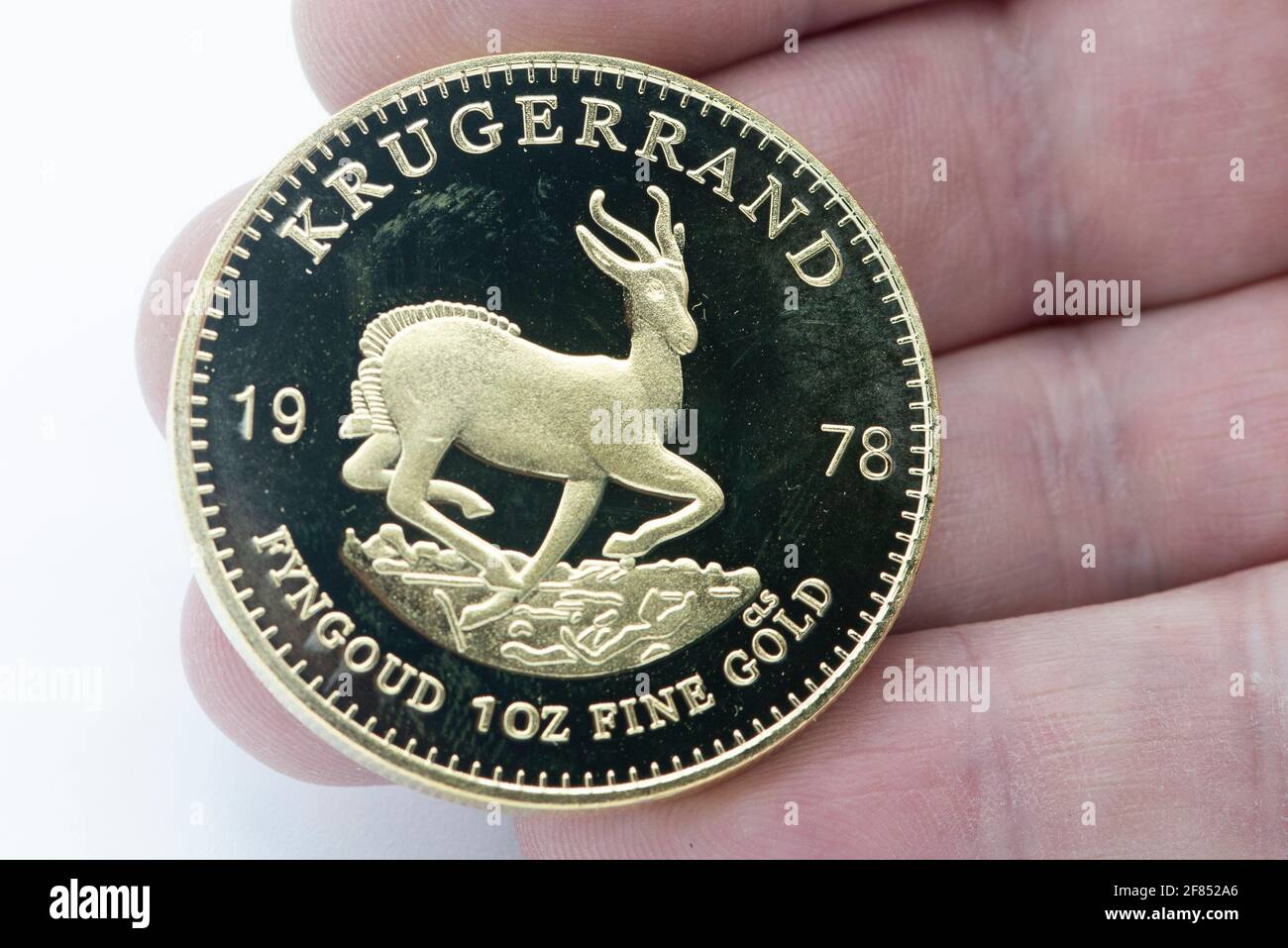 Un uomo può contenere una moneta d'oro da 1978 ml di Krugerrand Foto Stock