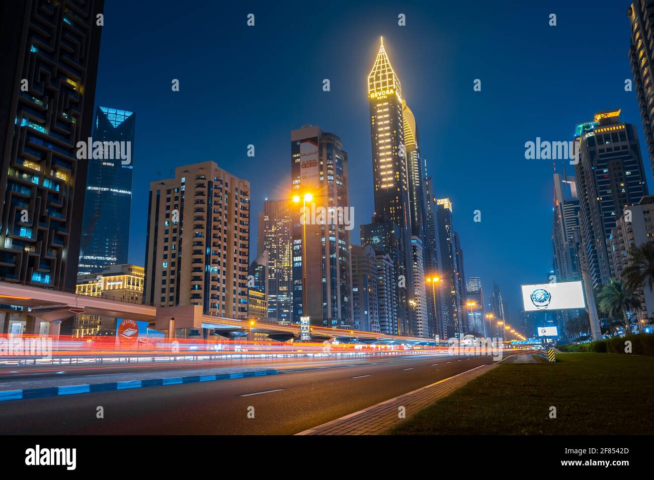 Dubai, Emirati Arabi Uniti - 31 marzo 2021: Centro di Dubai moderno skyline sopra Sheikh Zayed strada sulle autostrade più trafficate negli Emirati Arabi Uniti all'ora blu Foto Stock