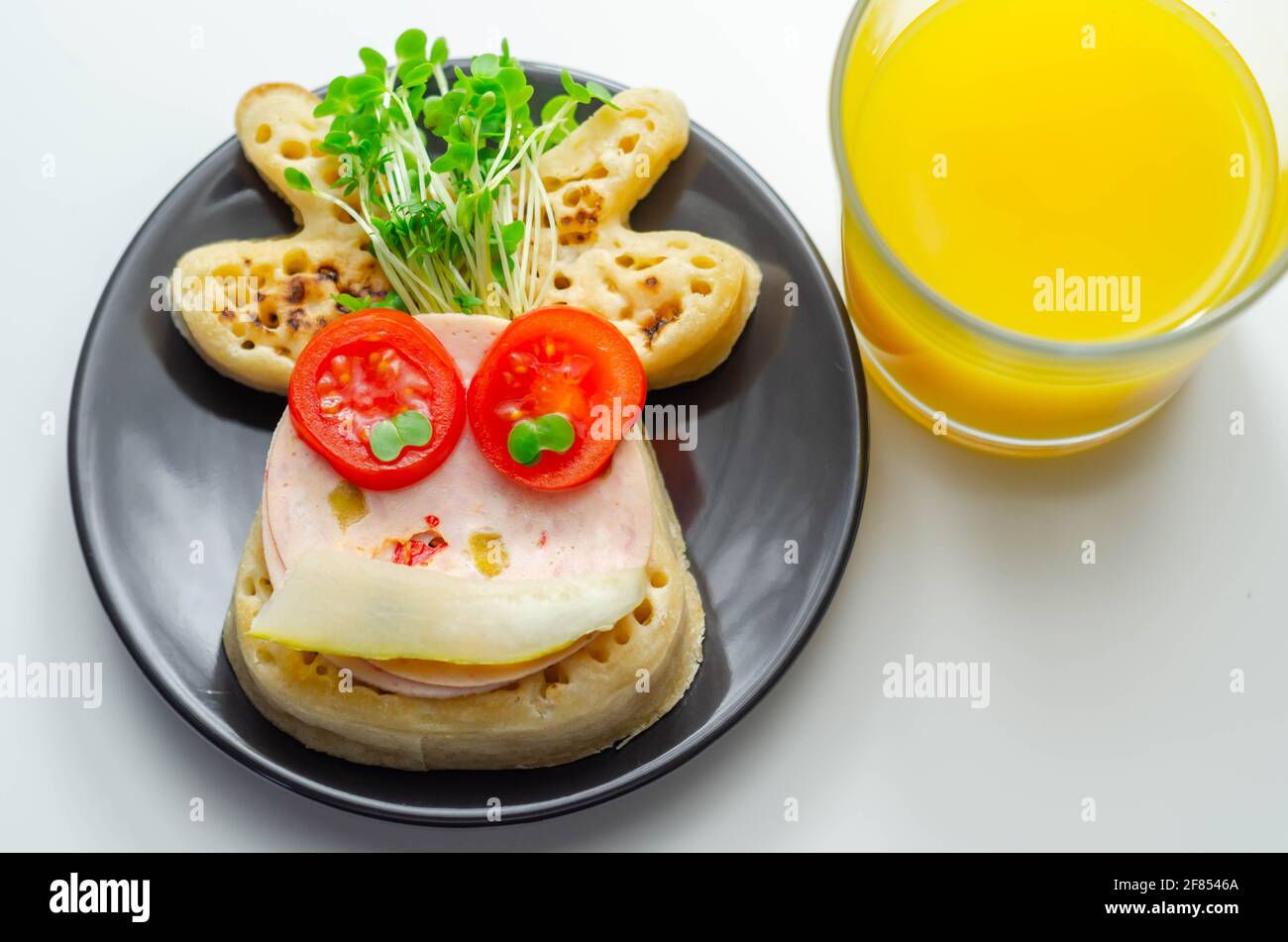 Briciole a forma di renna servite con prosciutto, pomodoro, cetriolo e crescione, cibo divertente Foto Stock