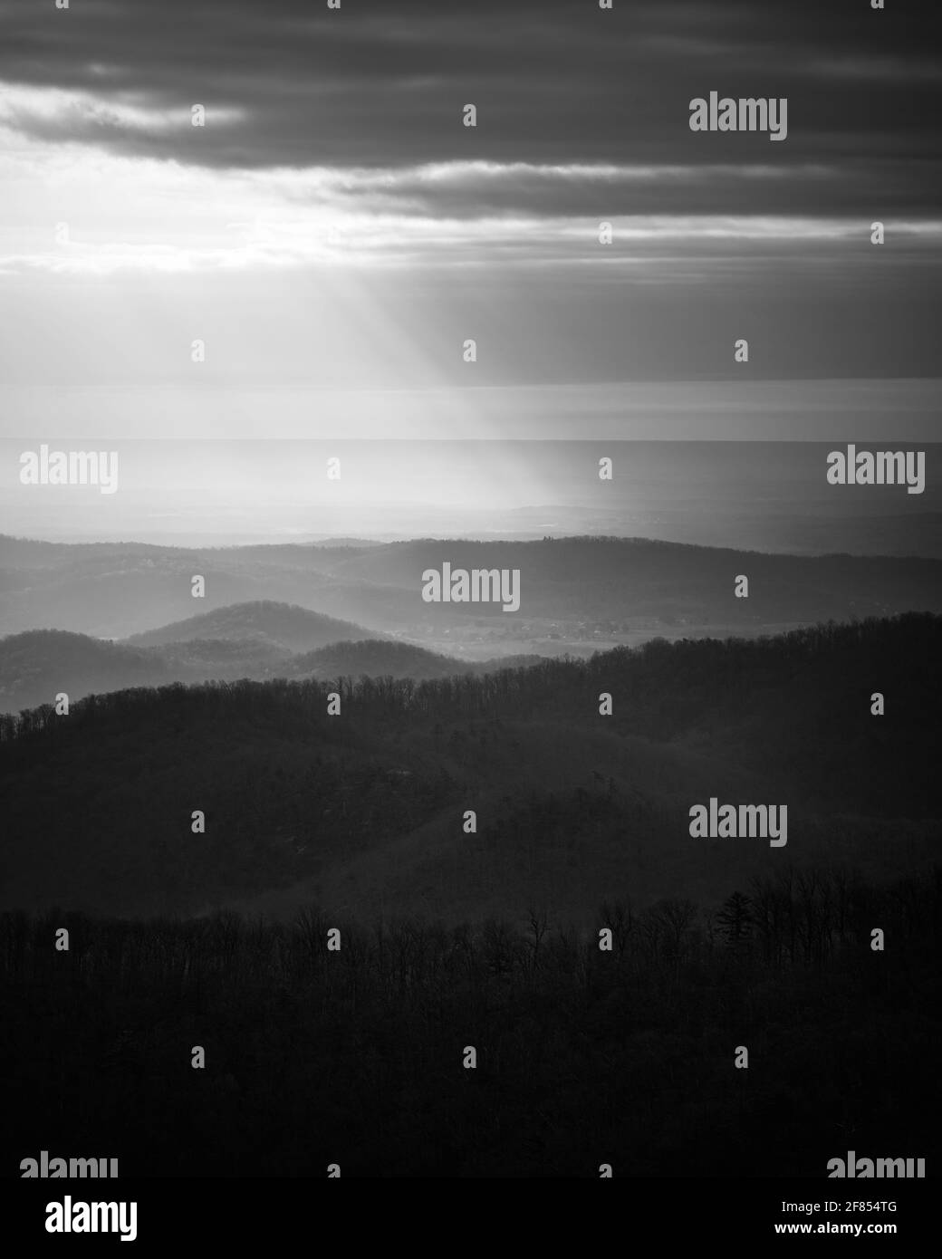 Intensi raggi di luce che brillano ai piedi delle colline del Parco Nazionale di Shenandoah, in bianco e nero. Foto Stock