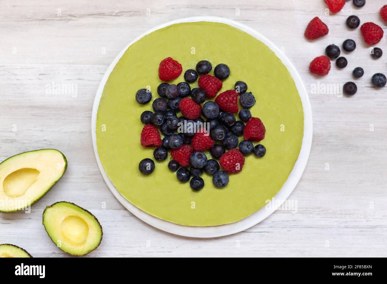 Gustoso avocado fatto in casa e torta al lime cruda con mirtilli e lamponi, ricette vegane sane Foto Stock