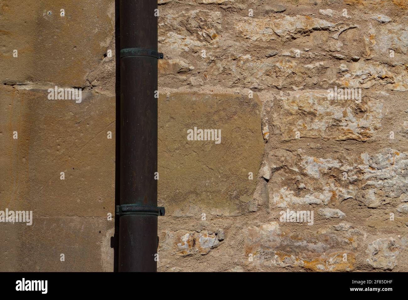 Tubo discendente di fronte ad un muro di pietra arenaria e pietra naturale con spazio per la copia Foto Stock
