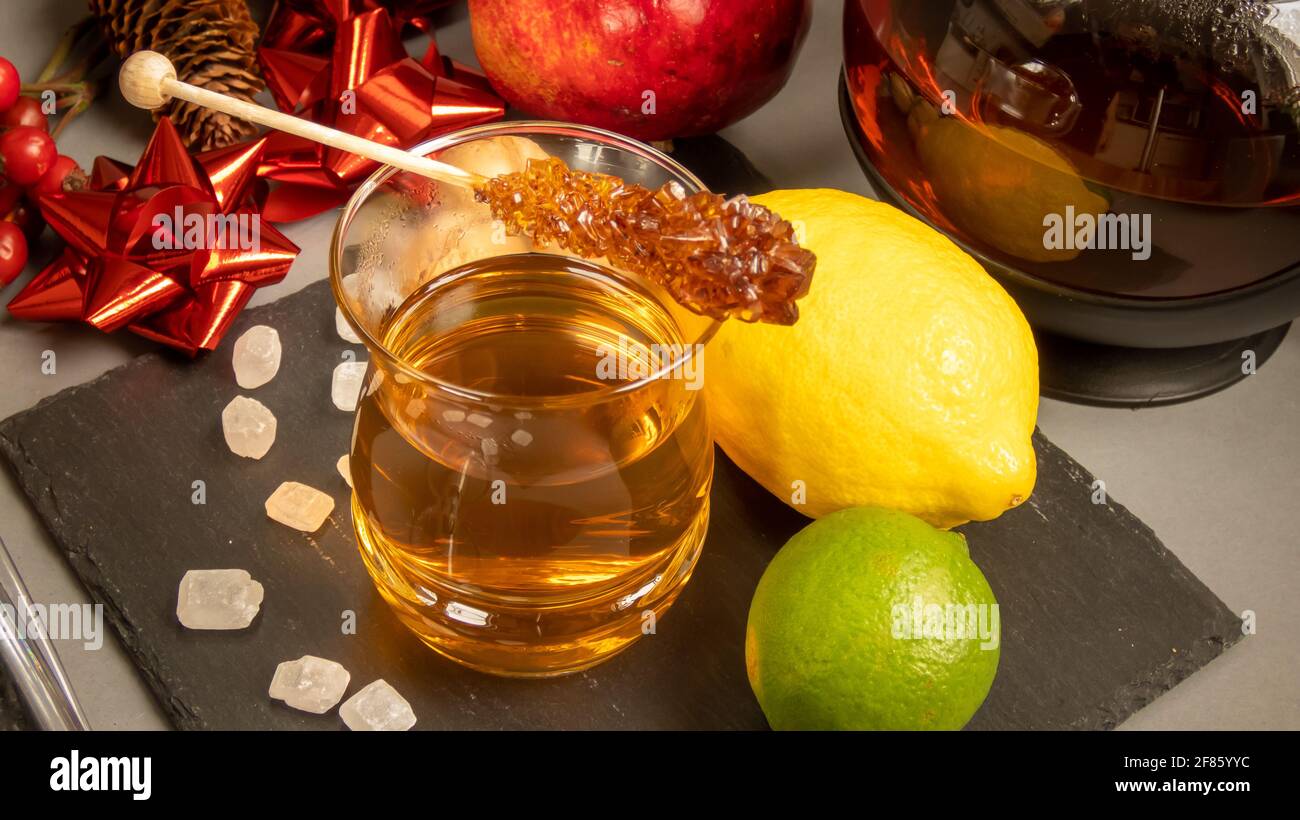 Primo piano di un bicchiere di tè caldo e un limone intero e un lime sul lato Foto Stock