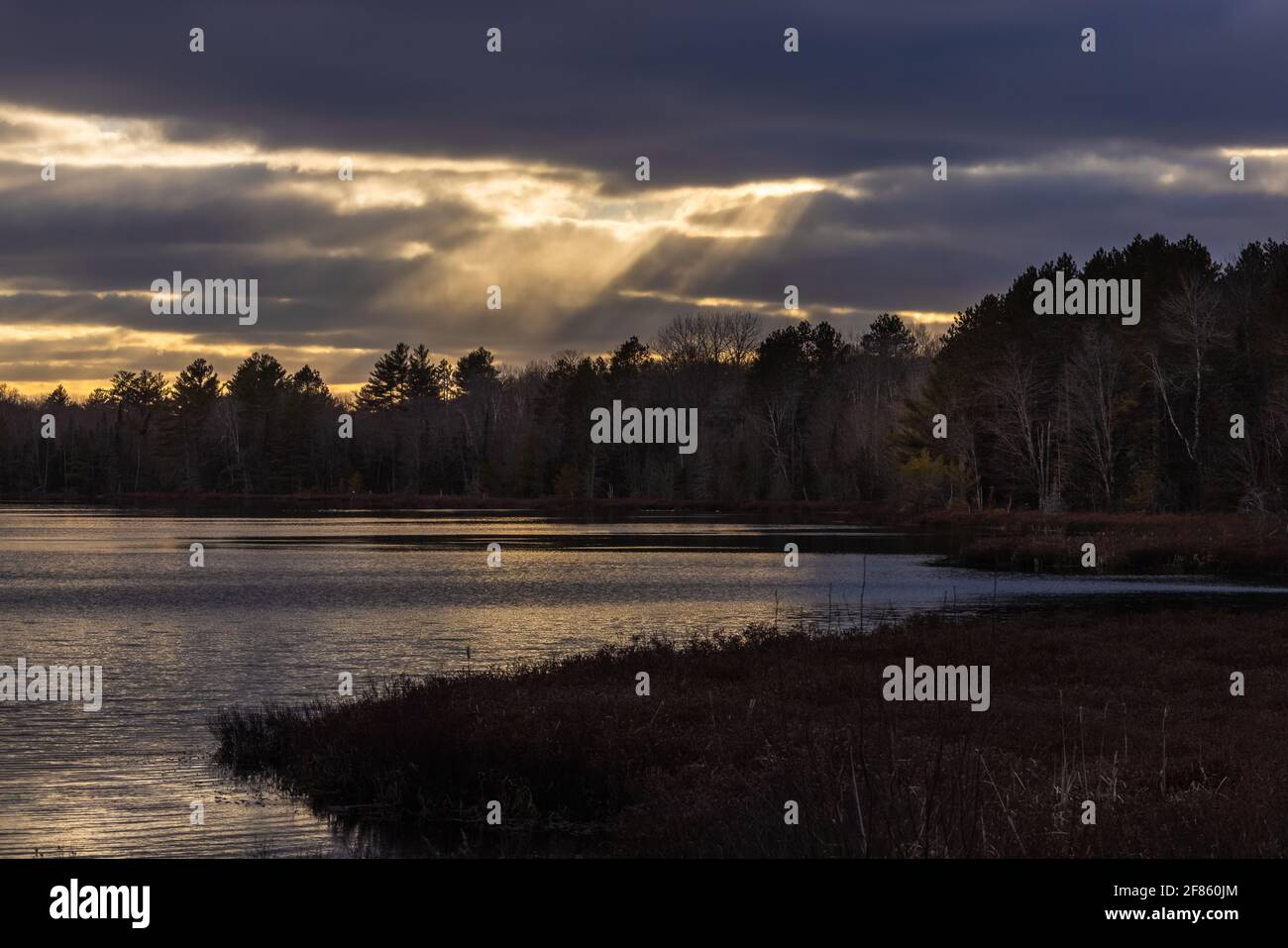 Raggi del sole sul lago Little Clam nel Wisconsin settentrionale. Foto Stock