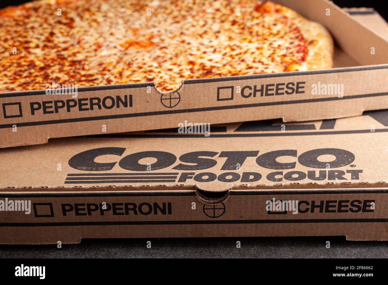Clarksburg, MD, USA 04-7-2021: Immagine ad angolo closeup di una scatola di cartone di deliziosa pizza al formaggio COSTCO su ordinazione. Cibo molto popolare a prezzi vantaggiosi c Foto Stock