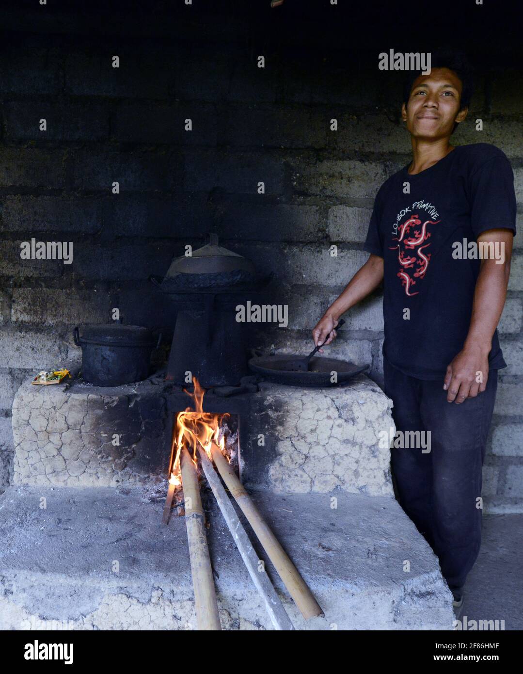 Un uomo balinese arrostire i chicchi di caffè. Foto Stock