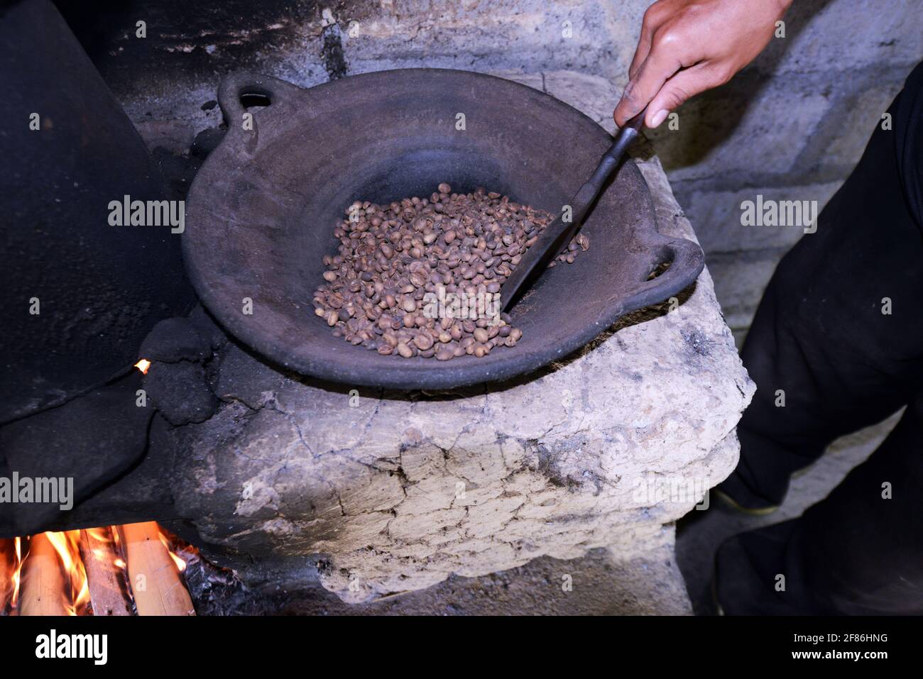 Un uomo balinese arrostire i chicchi di caffè. Foto Stock