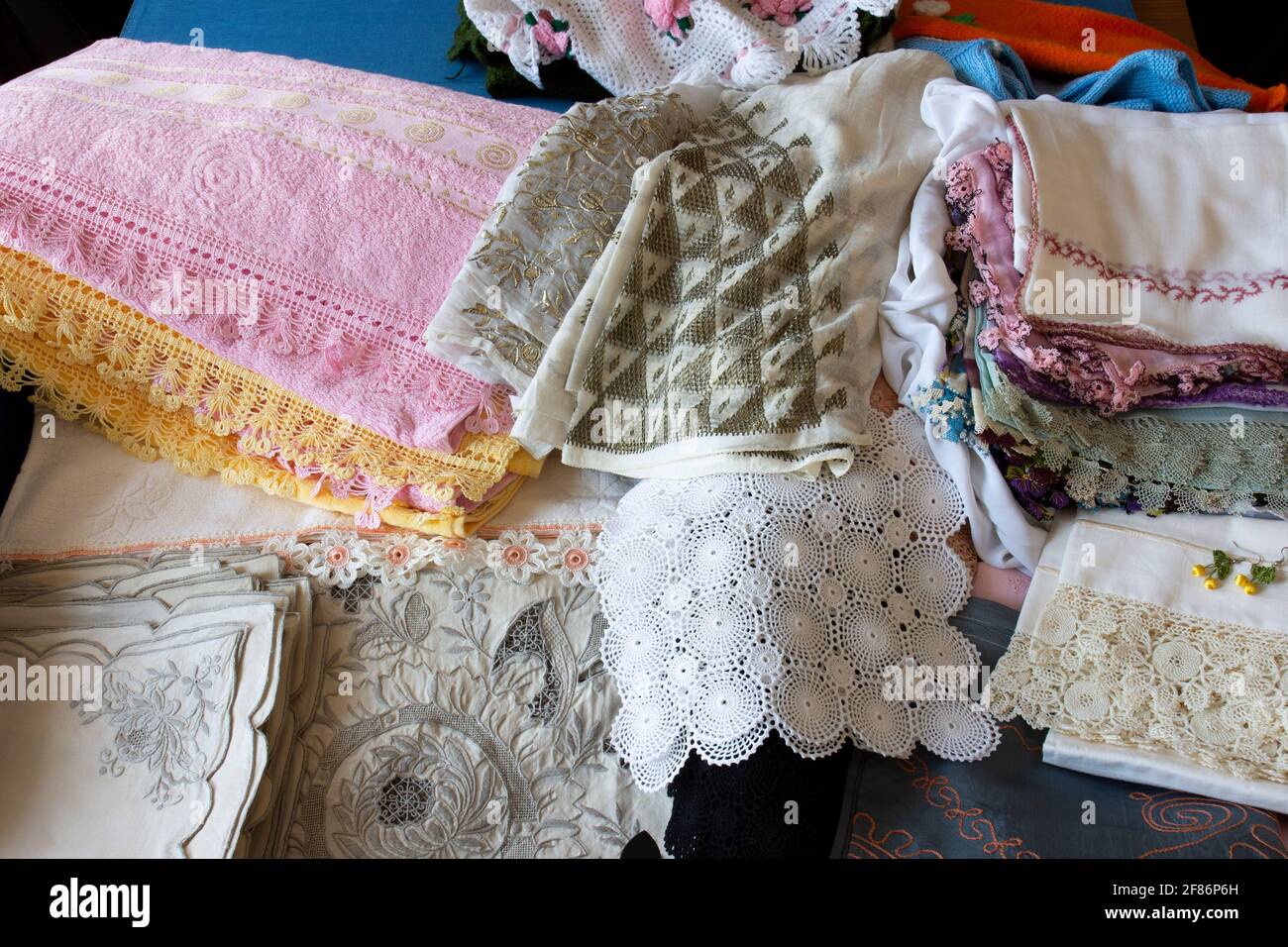 Dote in stile turco in un petto di dote blu, antichi cucchiai, piatti, asciugamani ricamati, mussola ricamata e pizzo. Braccio di messa a fuoco selettiva Foto Stock