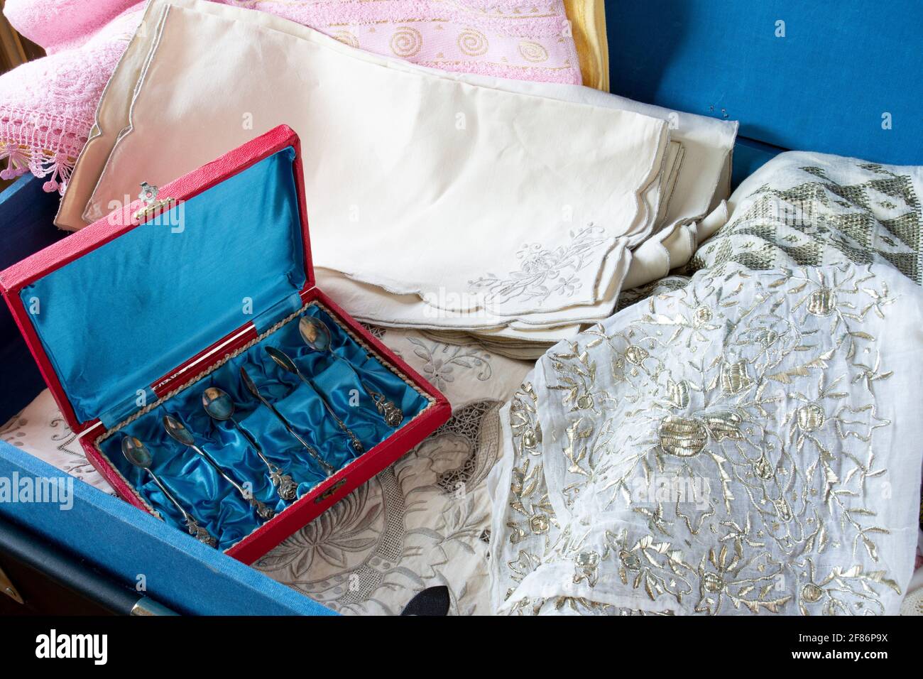 Dote in stile turco in un petto di dote blu, antichi cucchiai, piatti, asciugamani ricamati, mussola ricamata e pizzo. Braccio di messa a fuoco selettiva Foto Stock