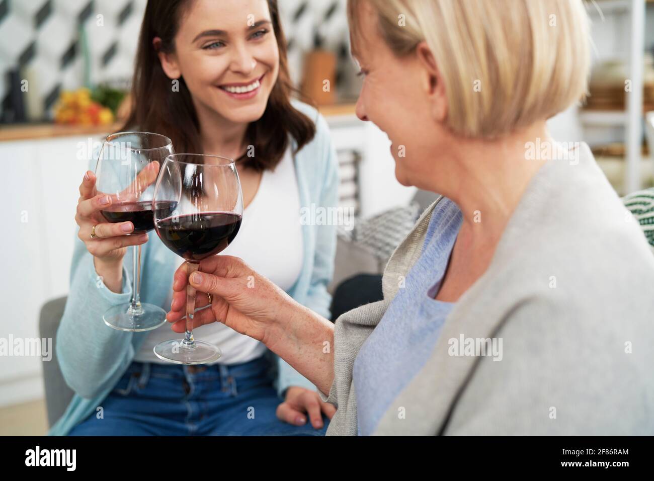 Buone donne che tostano nel vino a casa Foto Stock