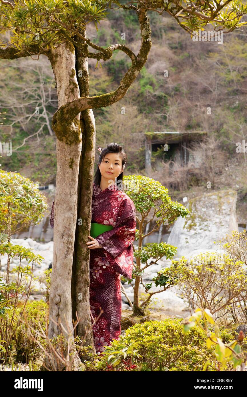 Bella giovane donna in kimono giapponese ad albero in tranquillità parcheggio Foto Stock