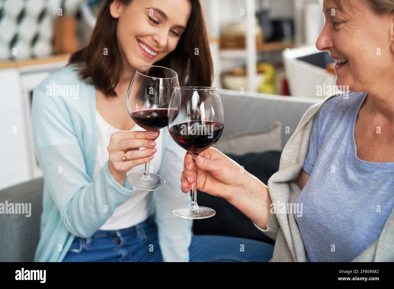 Madre e figlia tostano il vino durante la riunione di famiglia Foto Stock