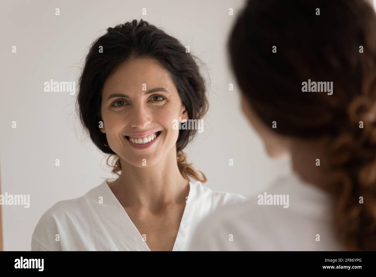 Head shot ritratto specchio riflesso di donna con sano sorriso Foto Stock