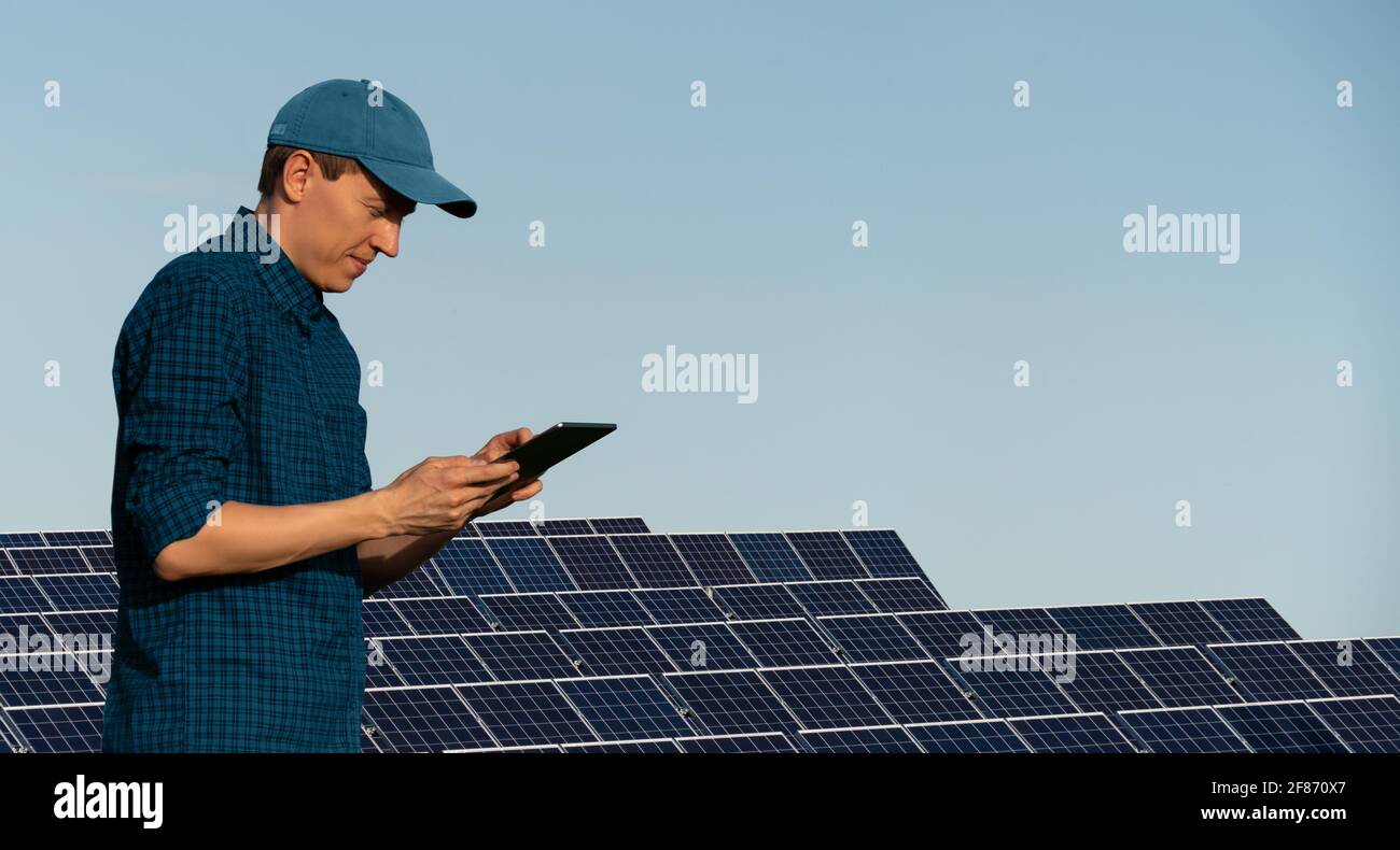 Ingegnere con computer tablet su uno sfondo di energia solare centrale elettrica Foto Stock