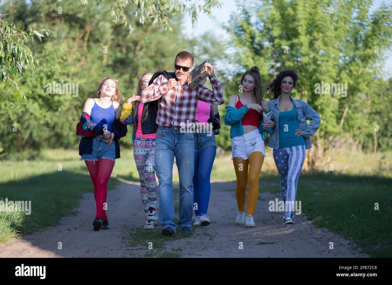 Un gruppo di giovani vestiti nello stile degli anni novanta cammina lungo  la strada Foto stock - Alamy