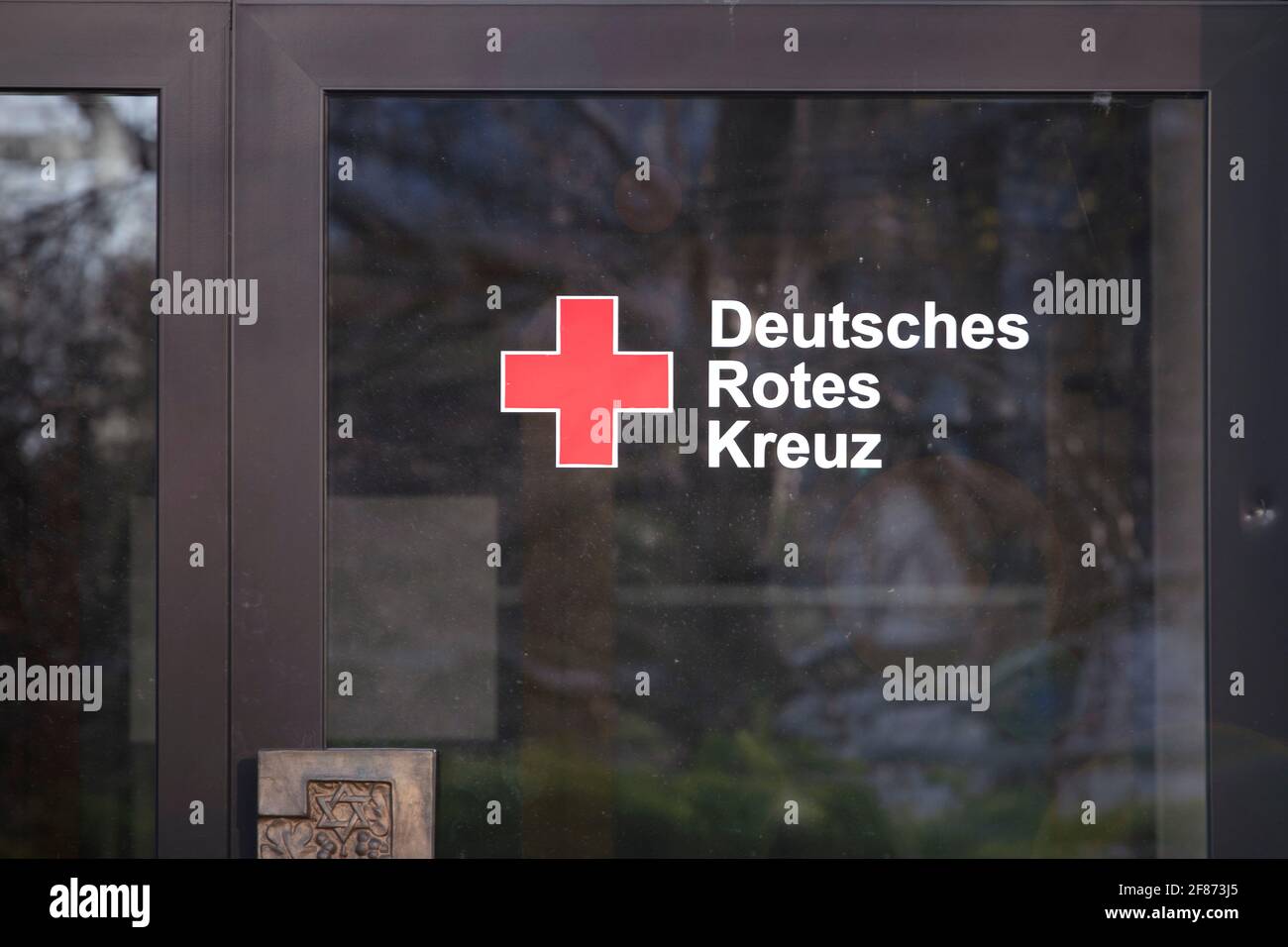 Grenzach-Wyhlen, Baden-Württemberg, Germania - 03.30.2021: Segno di 'Deutsches Rotes Kreuz' sulla porta. Logo della sezione tedesca croce rossa Foto Stock