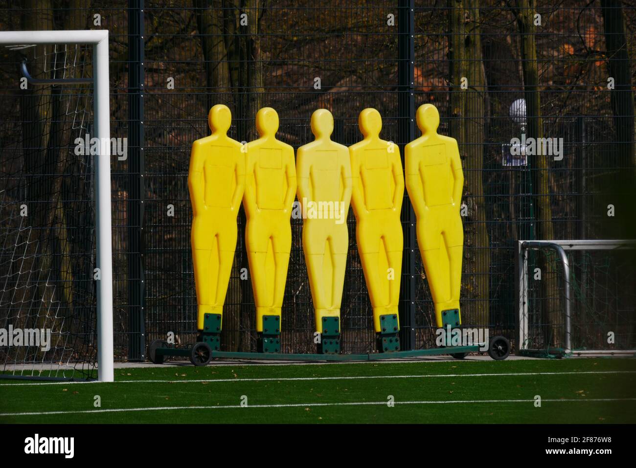 gnocchi di plastica gialla liberi del calcio sul bordo del campo accanto a un obiettivo Foto Stock
