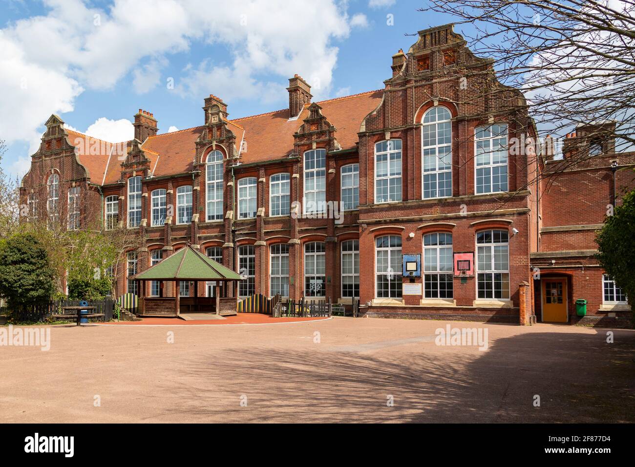 Una scuola britannica con un parco giochi vuoto e senza bambini Foto Stock