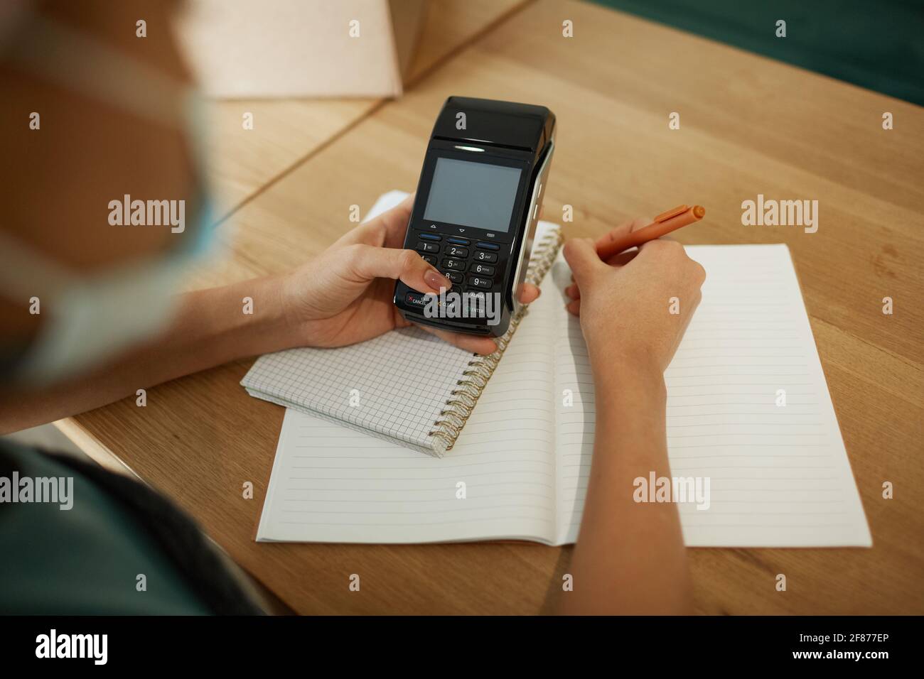 Alto angolo closeup di giovane afroamericana calcolando le finanze e facendo l'inventario al negozio di piccole imprese, spazio di copia Foto Stock