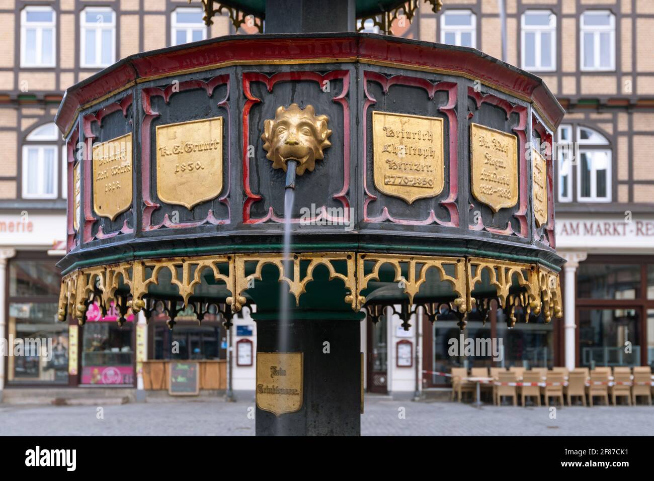 Wernigerode, Germania. 05 aprile 2021. Un getto d'acqua scorre dalla bocca di un leone dorato della fontana neo-gotica del benefattore. La fontana si trova nel centro storico di Wernigerode. Credit: Stefano Nosini/dpa-Zentralbild/ZB/dpa/Alamy Live News Foto Stock