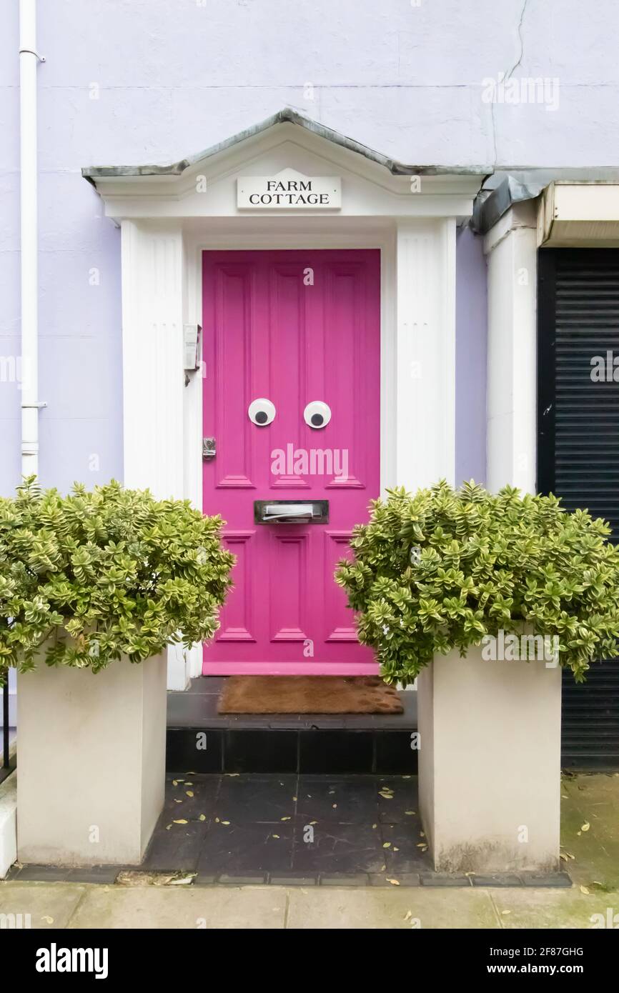 Farm Place, Kensington, Londra, Inghilterra, Regno Unito - Marzo 05 2021: Funny face pink door (W8) - solo per uso editoriale Foto Stock