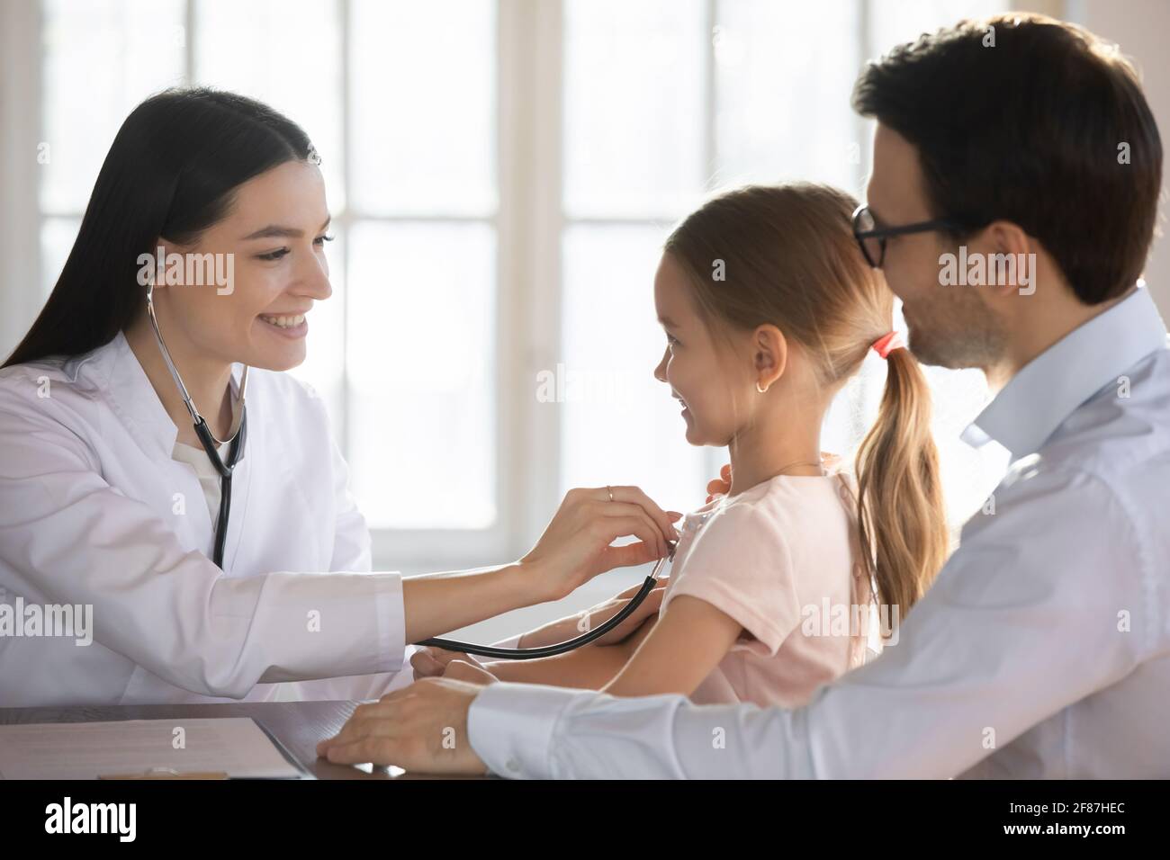 La pediatra femminile si prende cura di ascoltare il cuore del bambino con stetoscopio Foto Stock