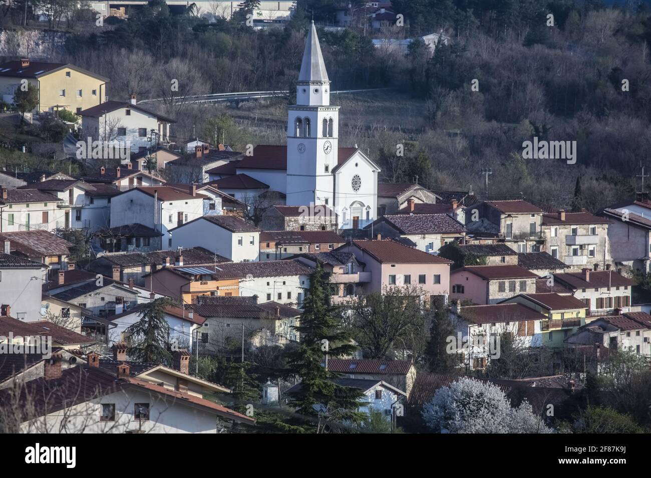 Tardo Afternon Tiro di Villaggio di Osek nella Valle di Vipava Slovenia. Situato nel mezzo della Valle. Surrogato da colline e zona coltivata. Molti Mon sacrale Foto Stock