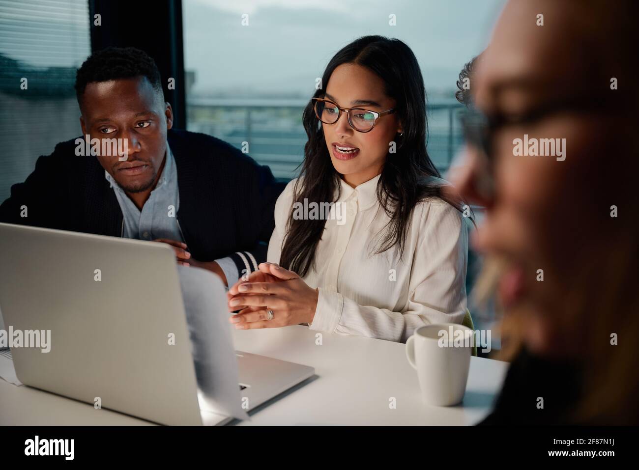 Una giovane manager fiduciosa che lavora con diverse collaboratrici ufficio Foto Stock
