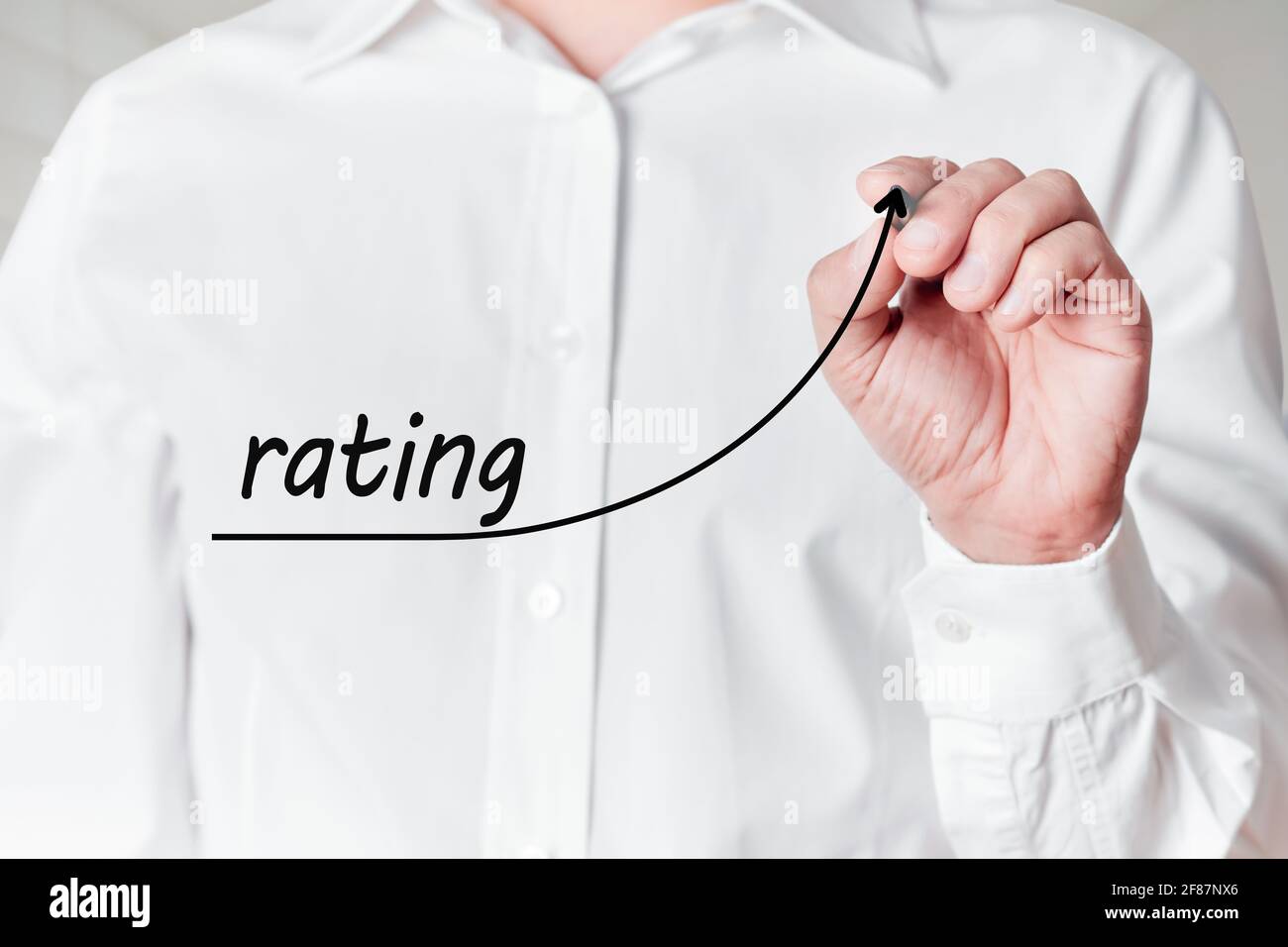 L'uomo d'affari con la penna disegna un grafico a linee ascendente con la valutazione della parola su uno schermo virtuale. Concetto di valutazione della soddisfazione del cliente Foto Stock