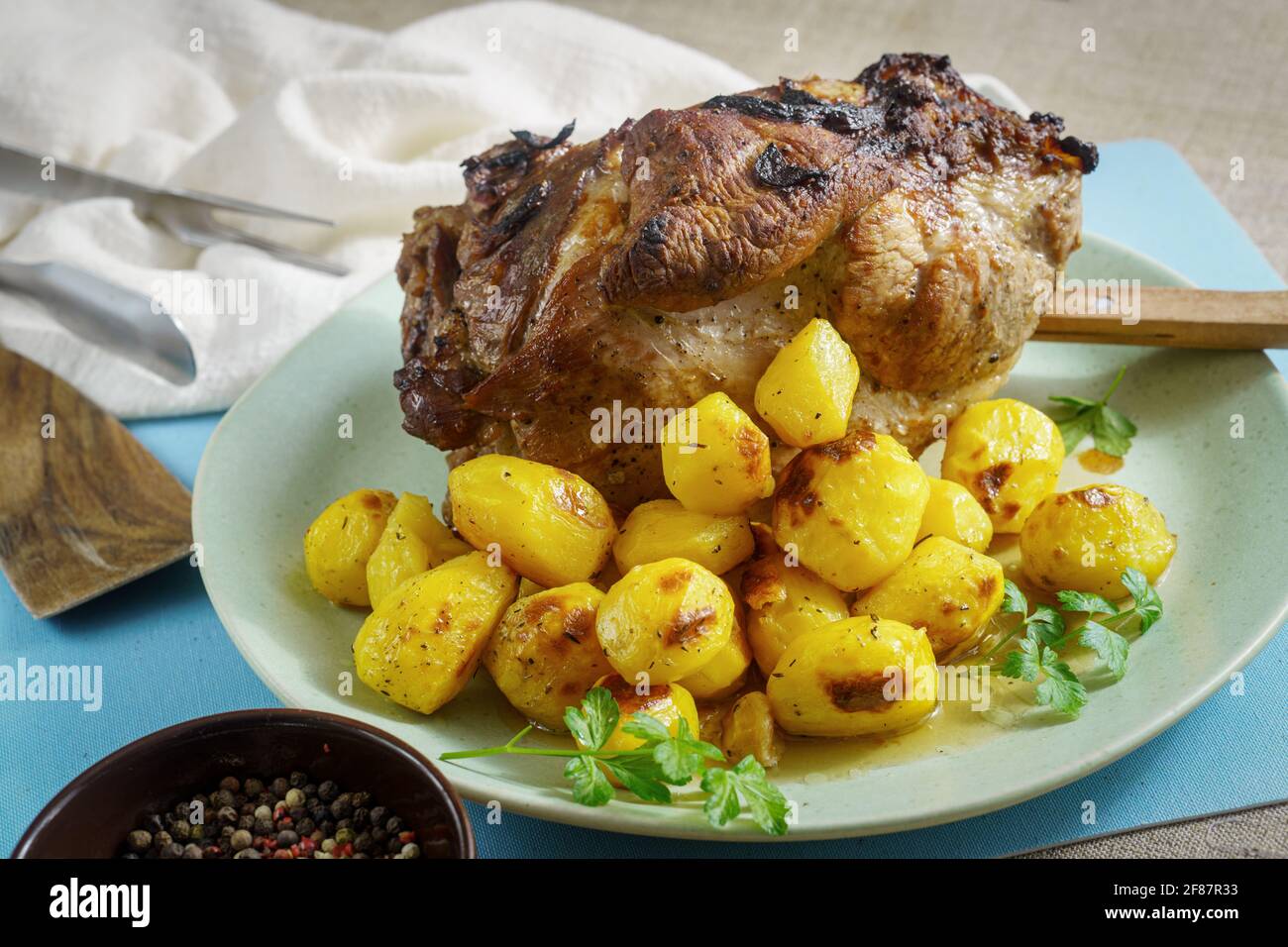 Spalla di maiale intera al forno con patate arrosto e spezie sulla piastra  Foto stock - Alamy