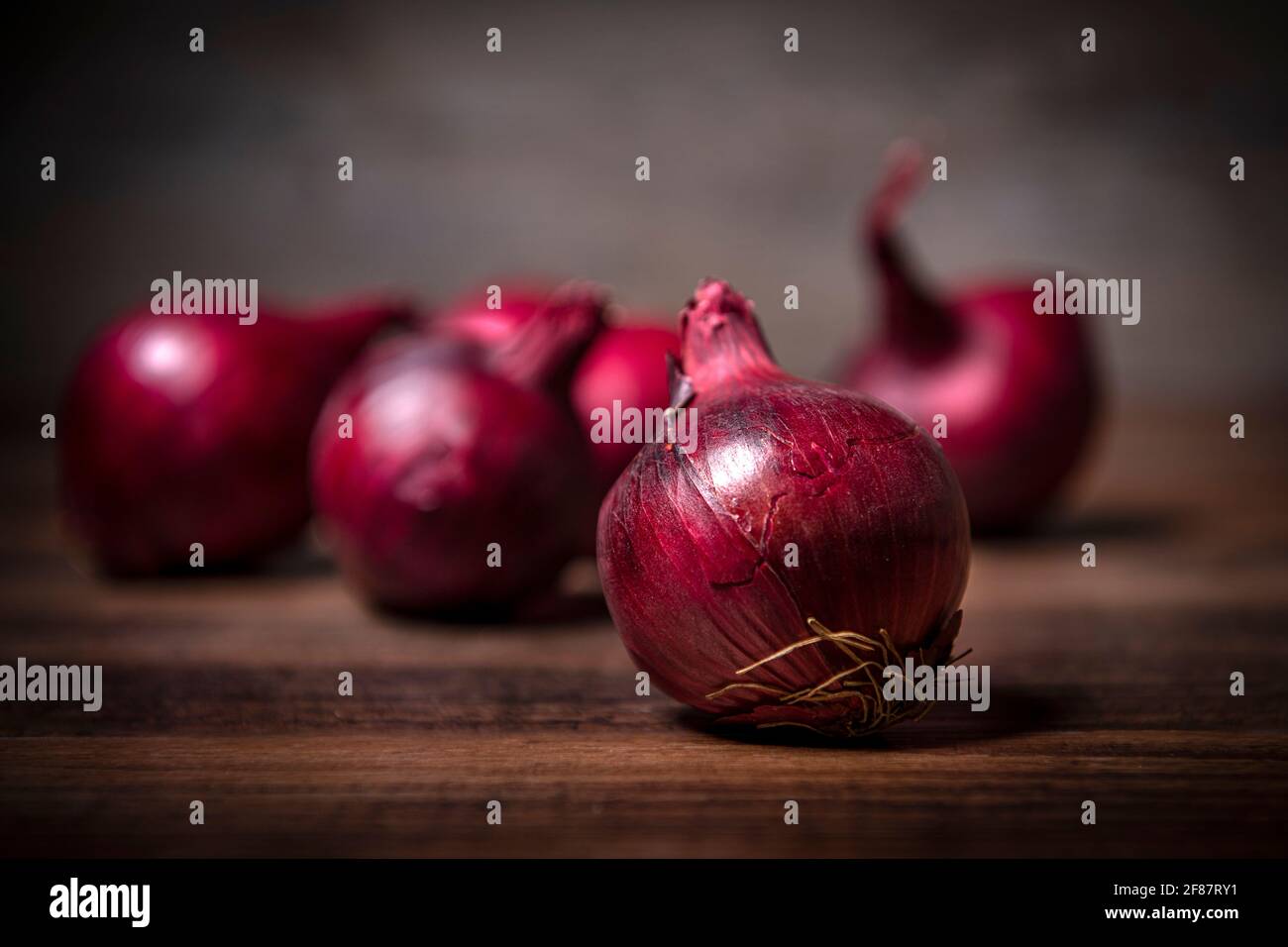 Cipolle rosse su una superficie di legno. Verdure fresche, biologiche fattoria. Foto Stock