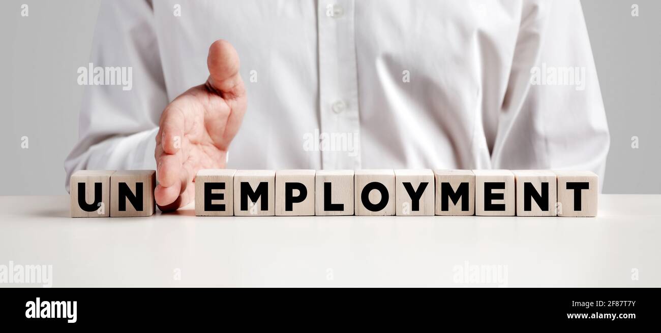 Mano di uomo d'affari mette via le prime due lettere dalla parola disoccupazione e la trasforma in occupazione. Risolvere il problema della disoccupazione. Foto Stock