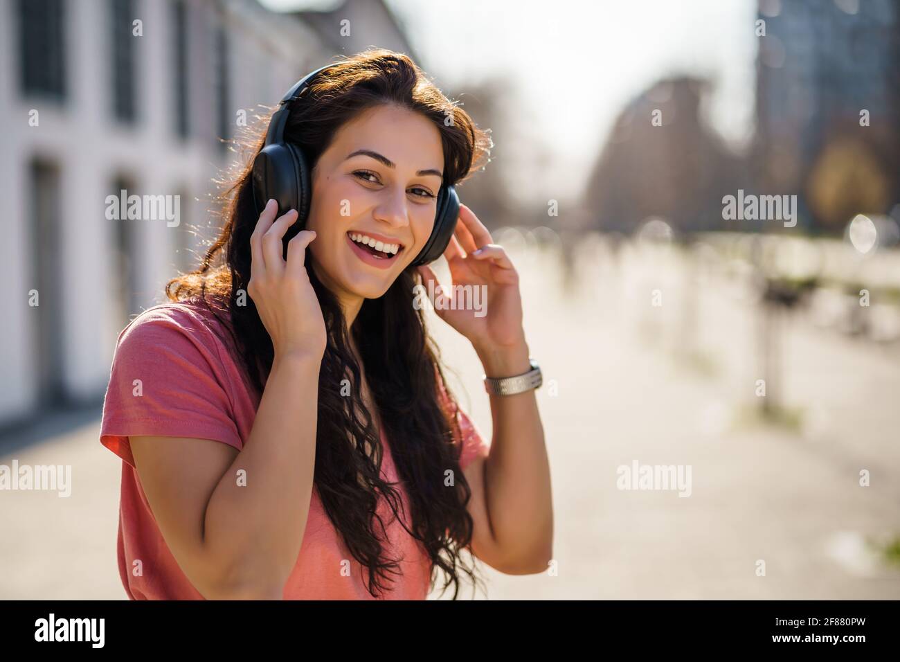 Felice giovane donna sta godendo di una giornata di sole all'aperto in città. Foto Stock